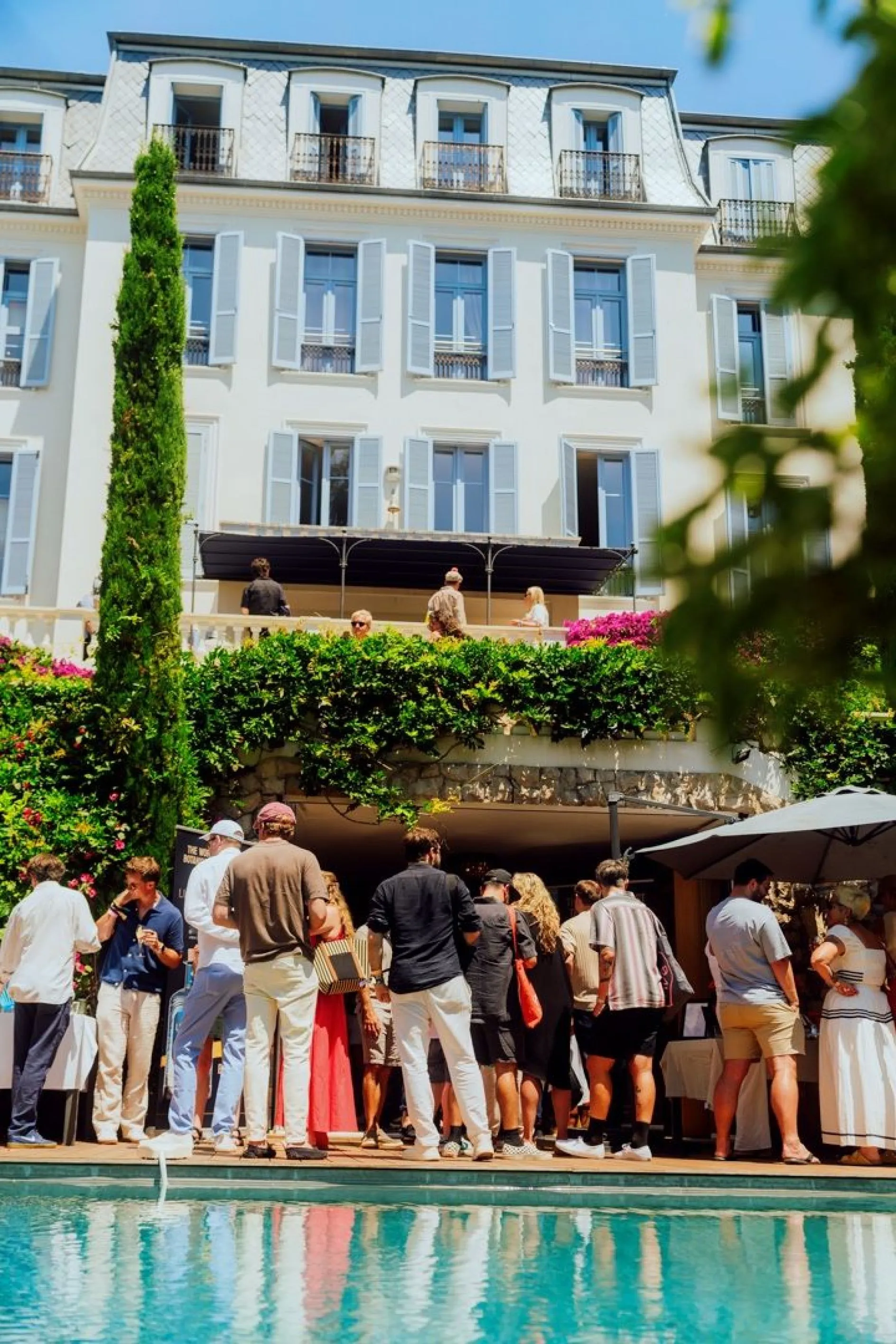 Guests gathered beside the pool in front of COLLINS House in Cannes
