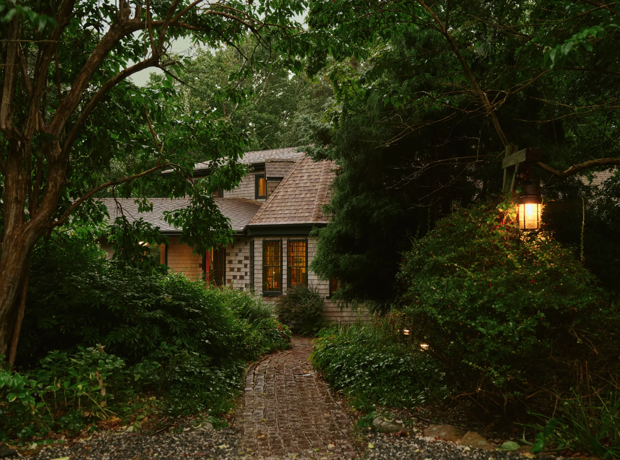 A brick path through the trees to the Treehaus studio at dusk