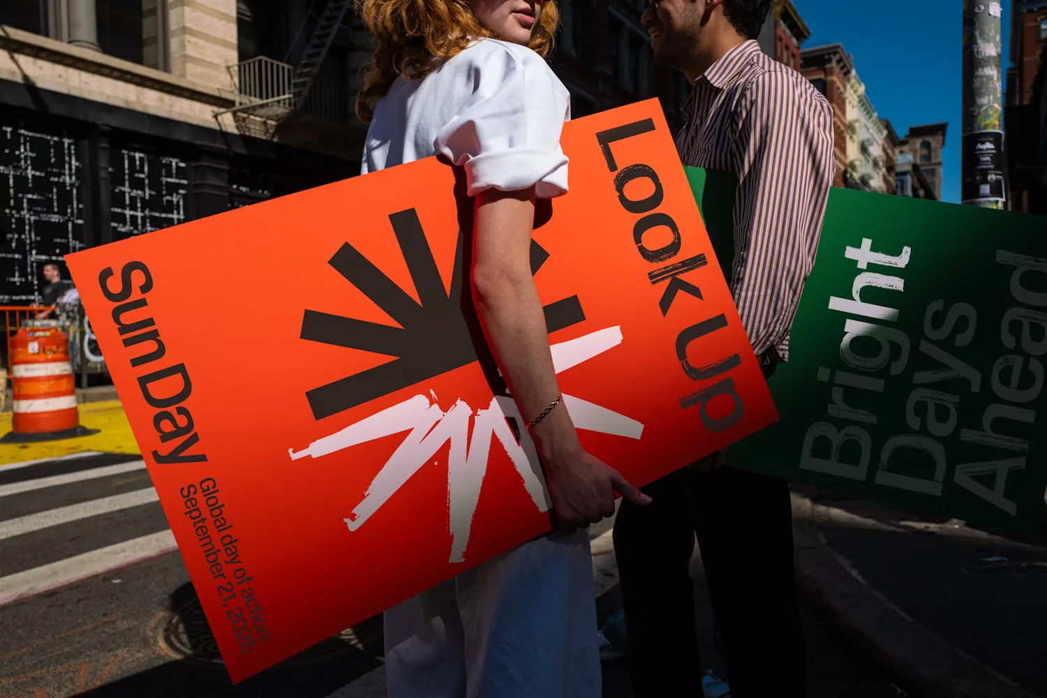Marchers carrying orange Sun Day posters printed with the half-sun symbol